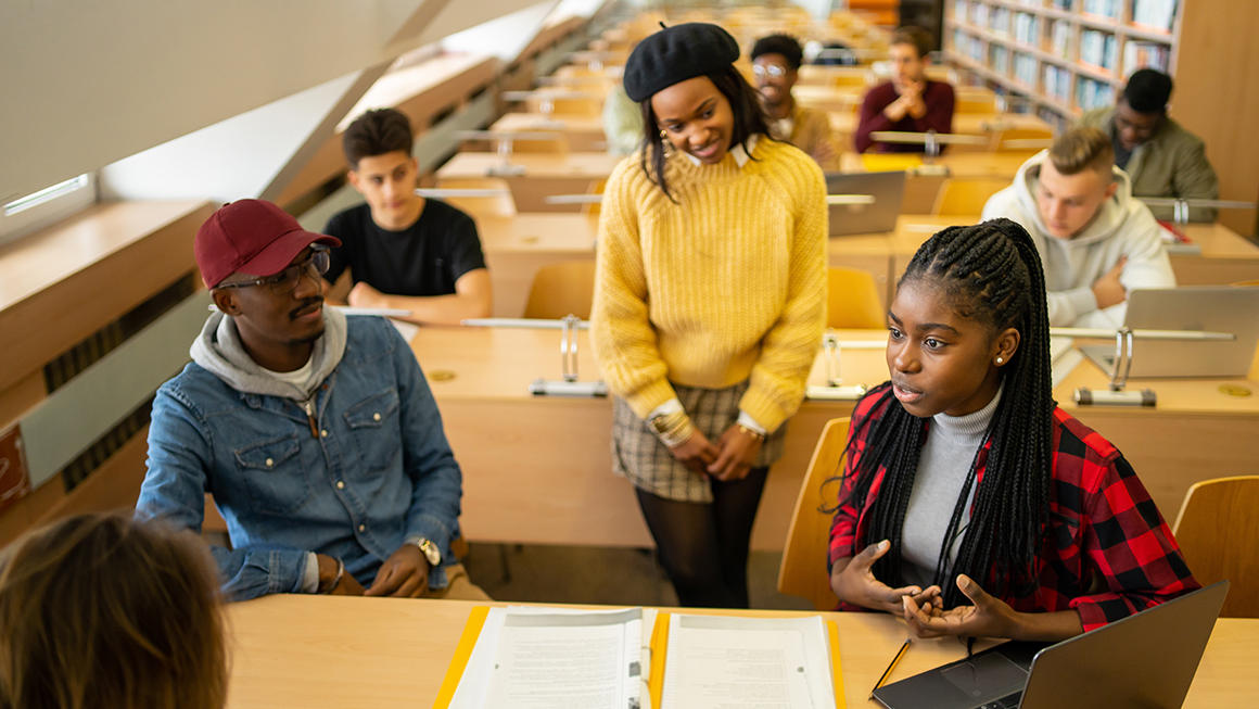 photo of students talking together in a classroom