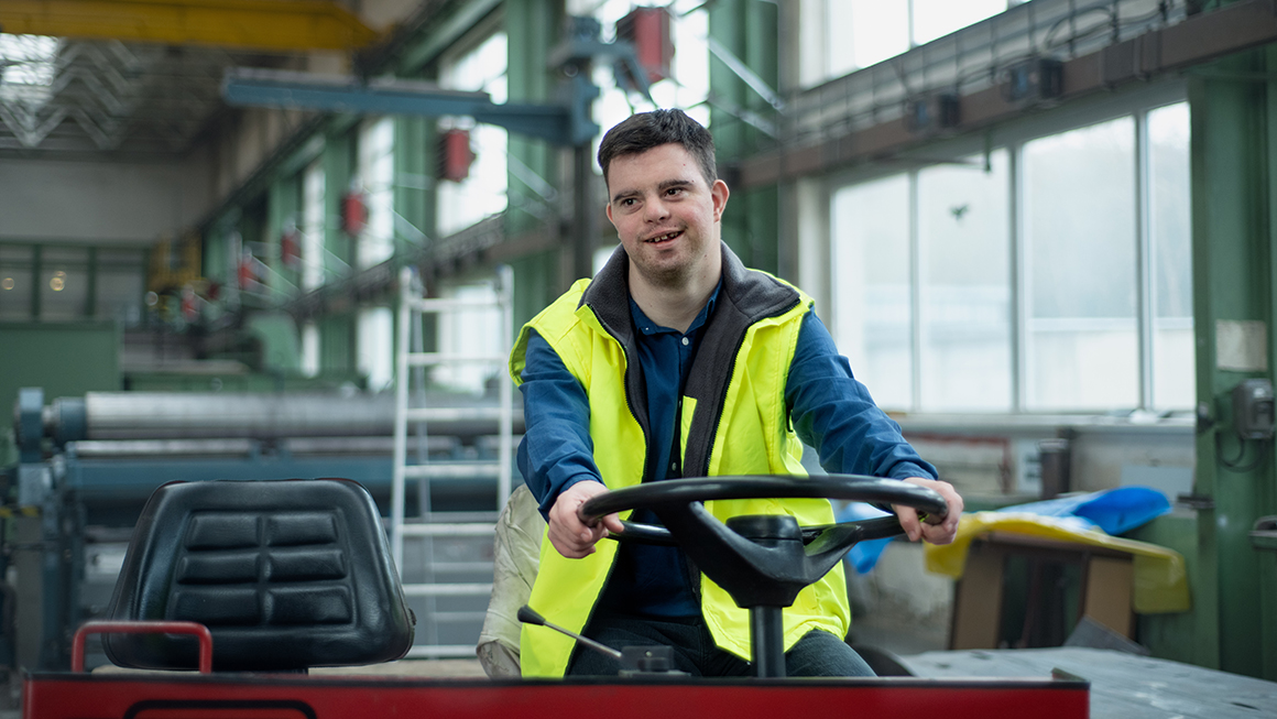 photo of young man with Down syndrome working in industrial factory