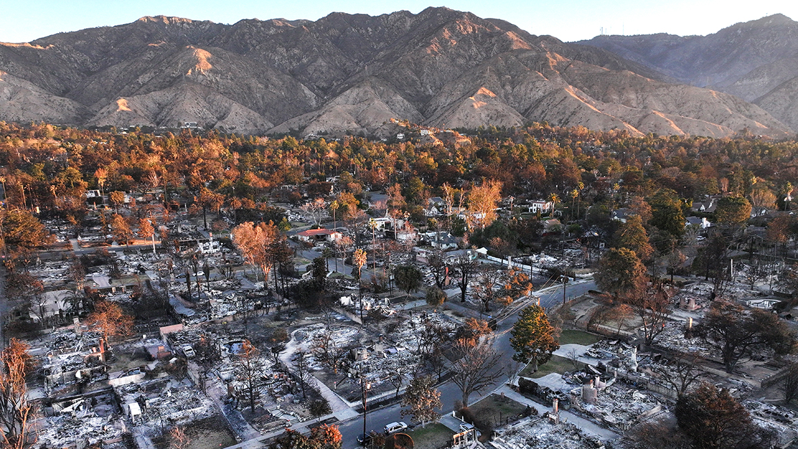 photo of an aerial view of the sun rising beyond homes which burned in the Eaton Fire on January 21, 2025 in Altadena, California