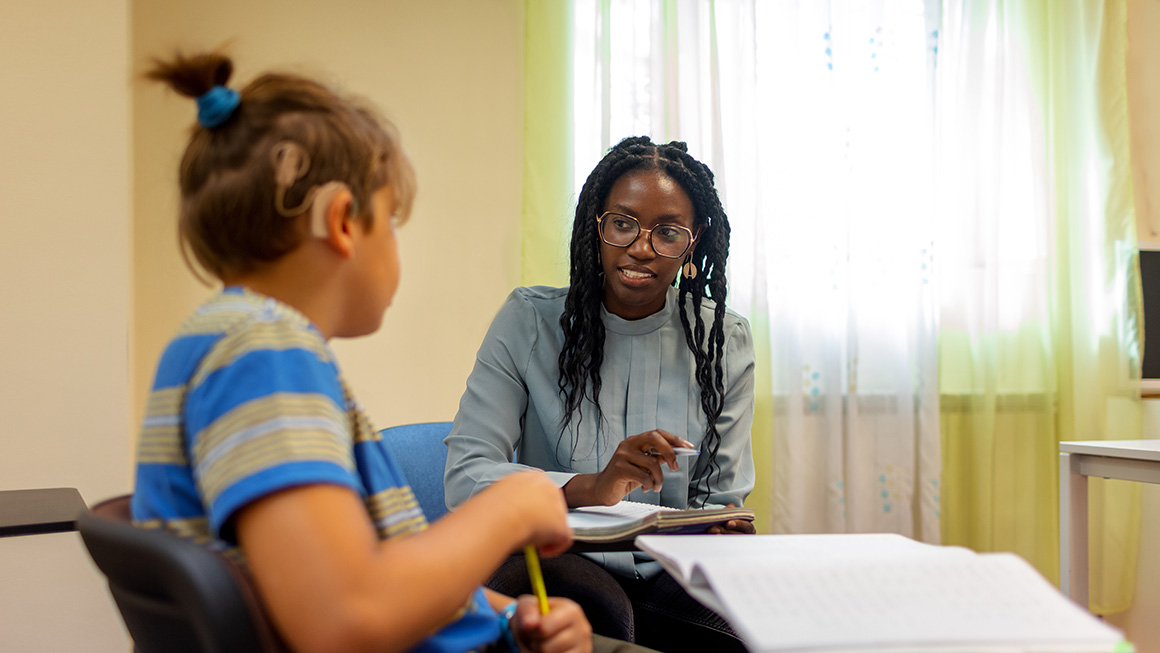 photo of teacher working with student in the classroom
