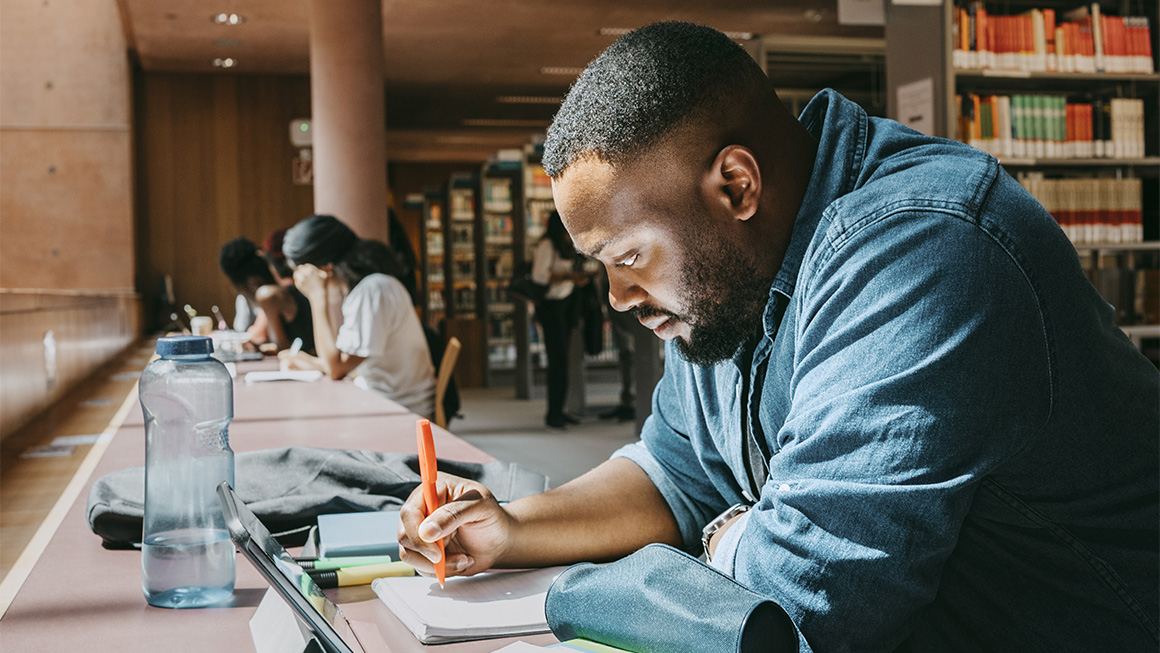 An adult student studies at a library.