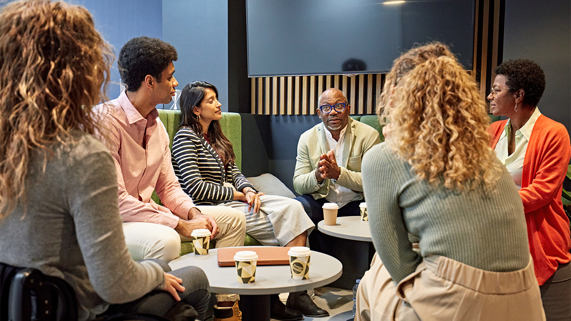 A group of people talking around a circle.