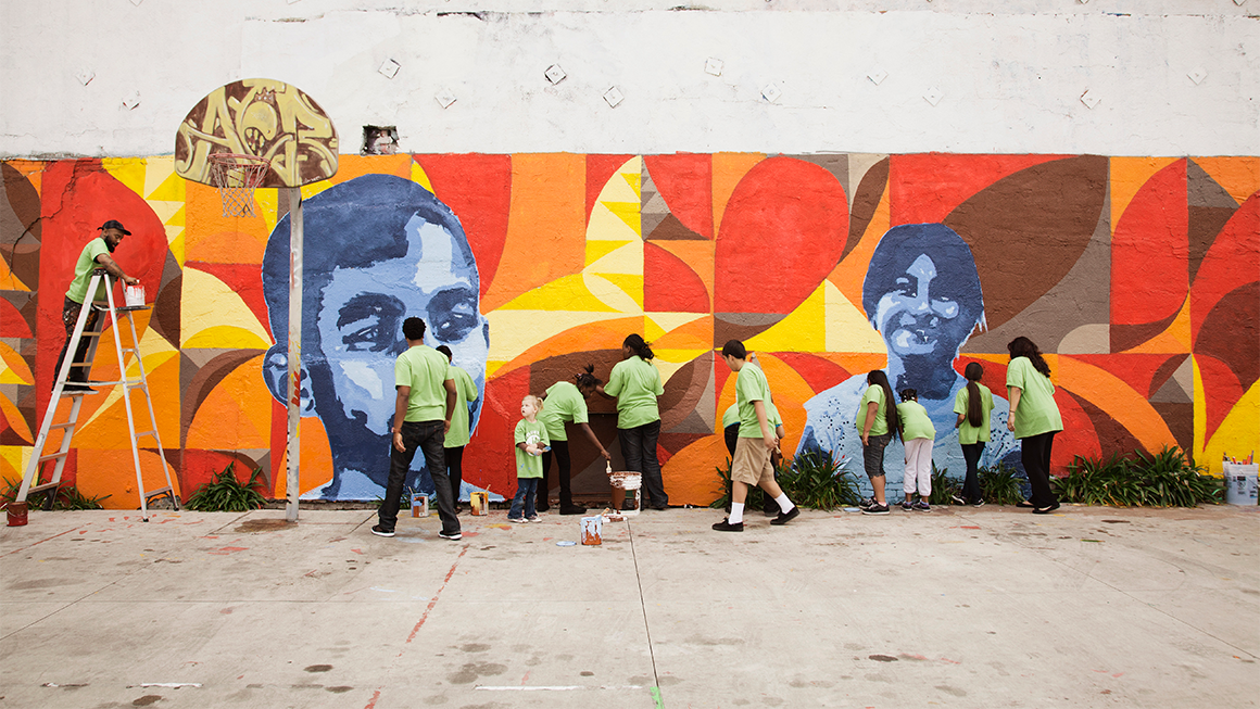 People painting a mural outside.