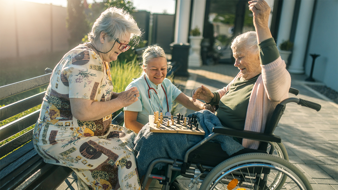 Seniors play chess on a park bench
