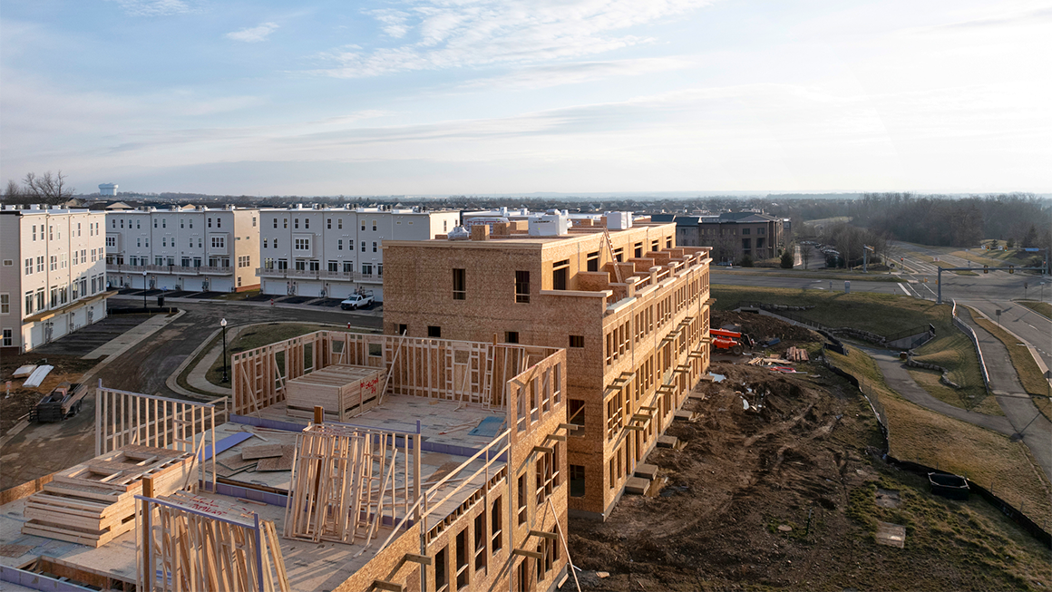 An aerial view of multifamily apartment buildings under construction. 