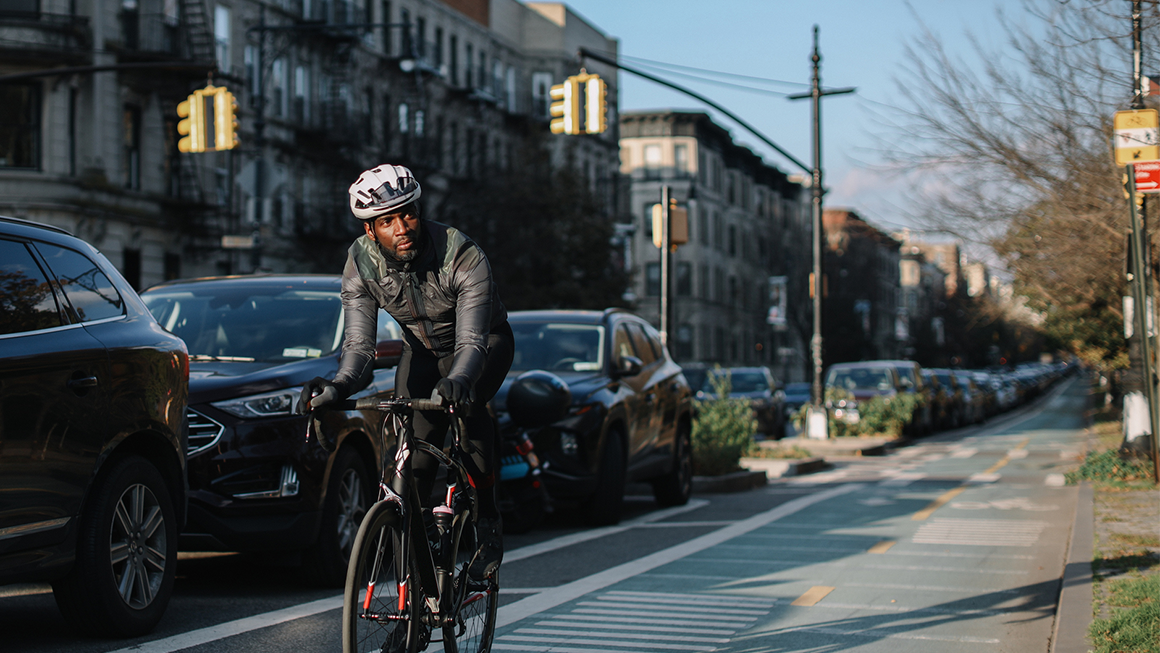 A cyclist riding in a bike line in an urban area.