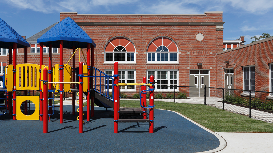 A colorful jungle gym outside an elementary school.