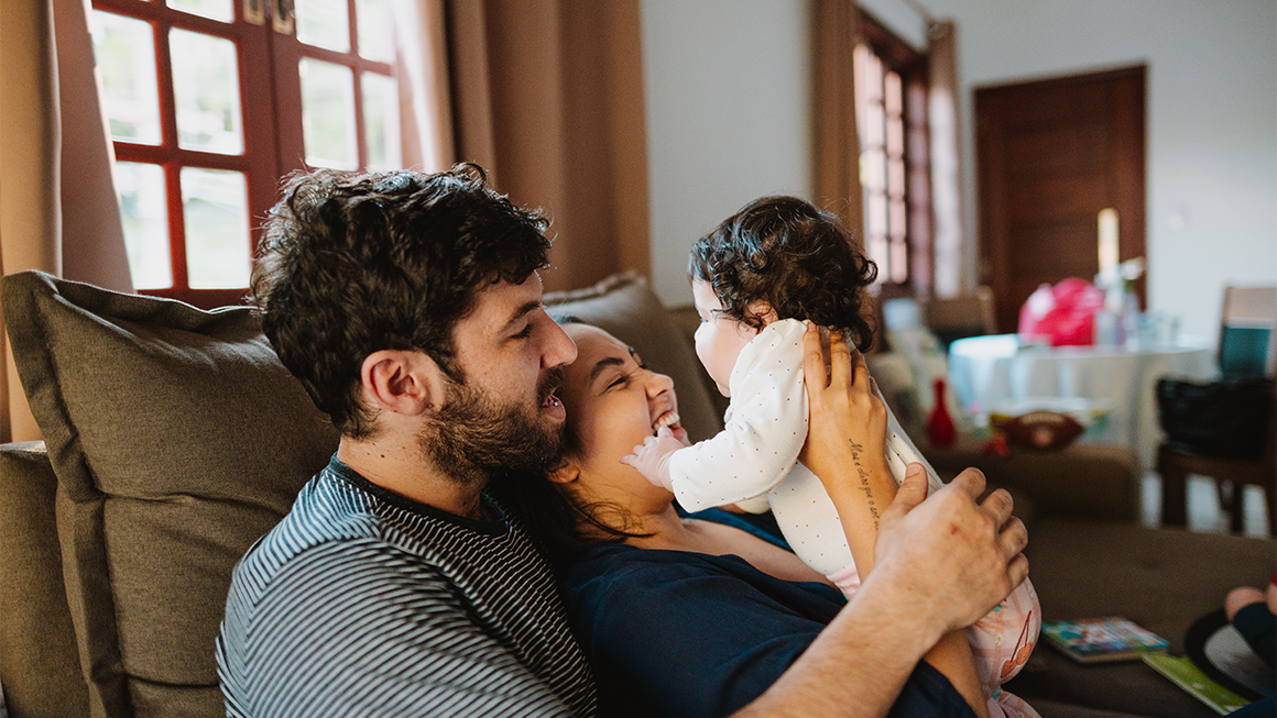 Two young parents holding their baby.