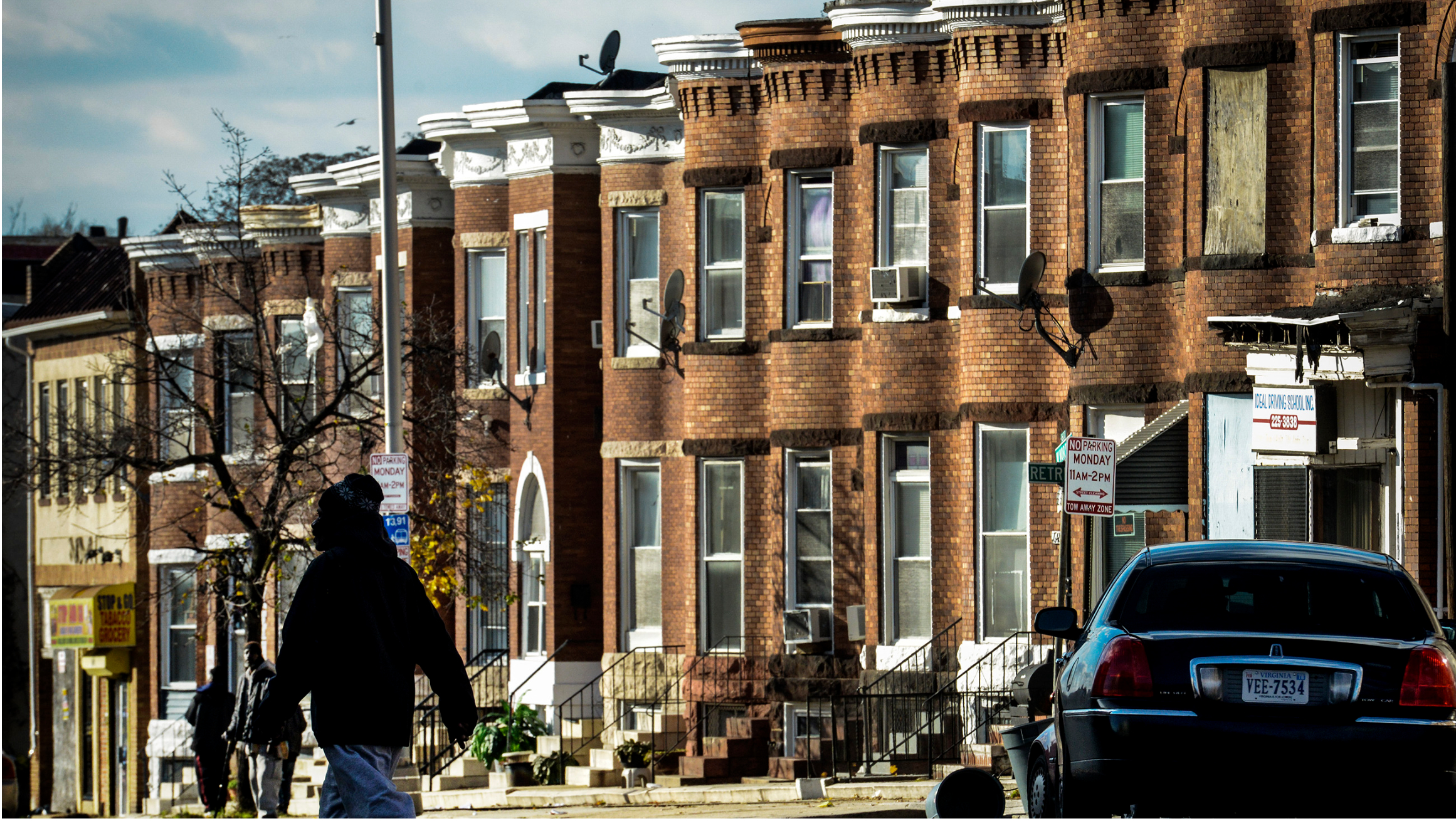 Row houses along a city street with a pedestrian crossing.