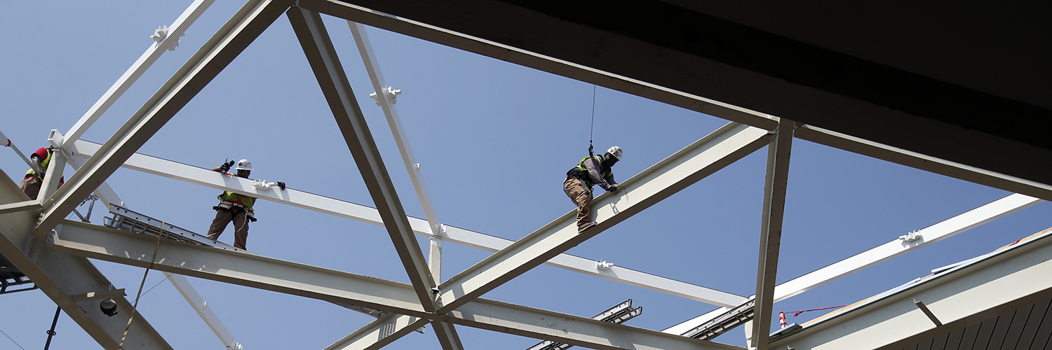 Ironworkers climb a building