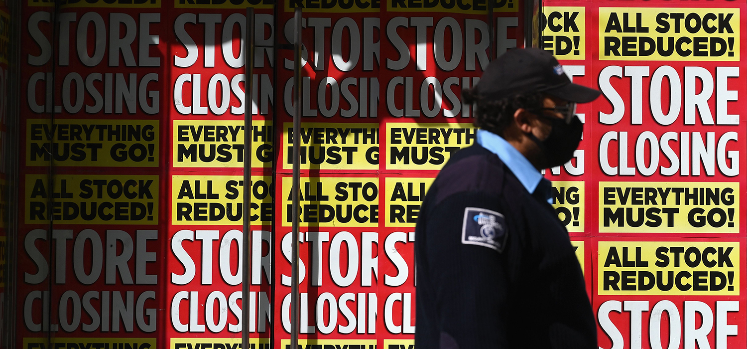 Man walks in front of a store that's going out of business