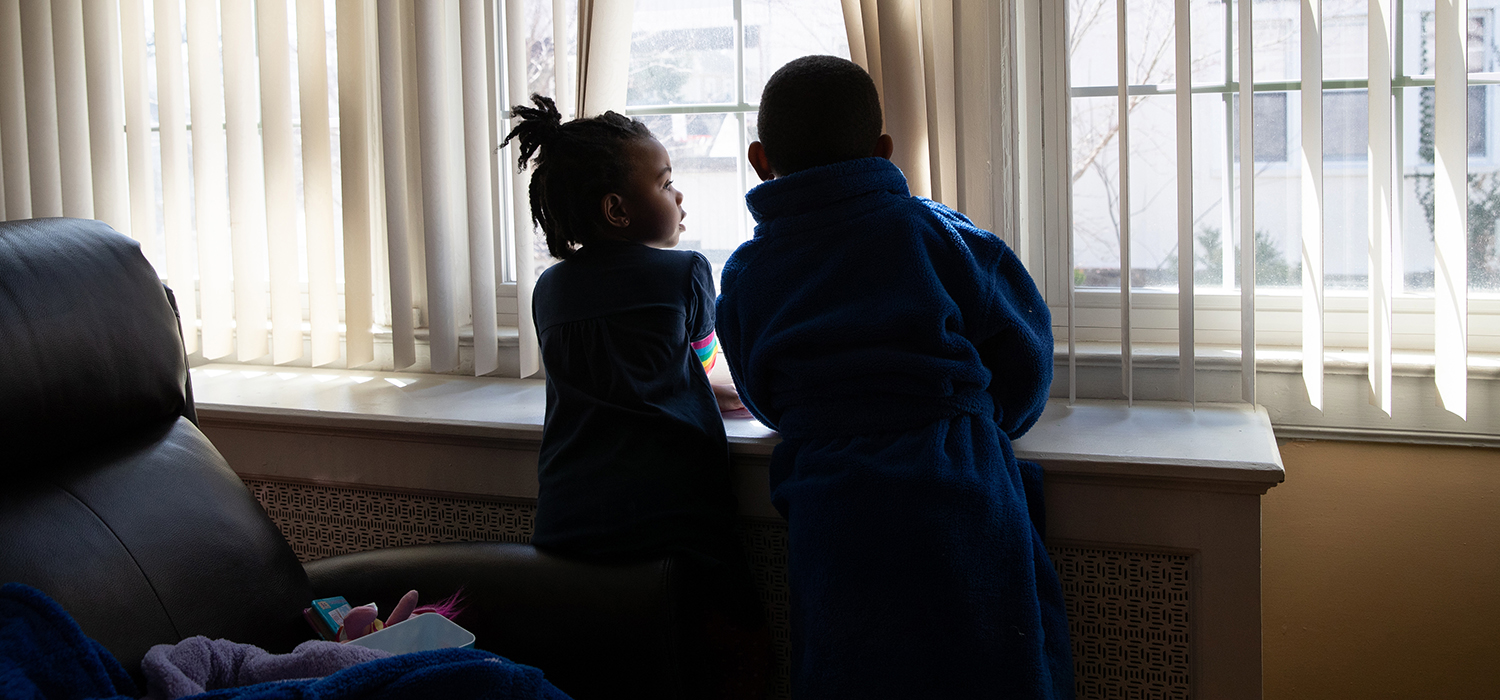Children look outside a window