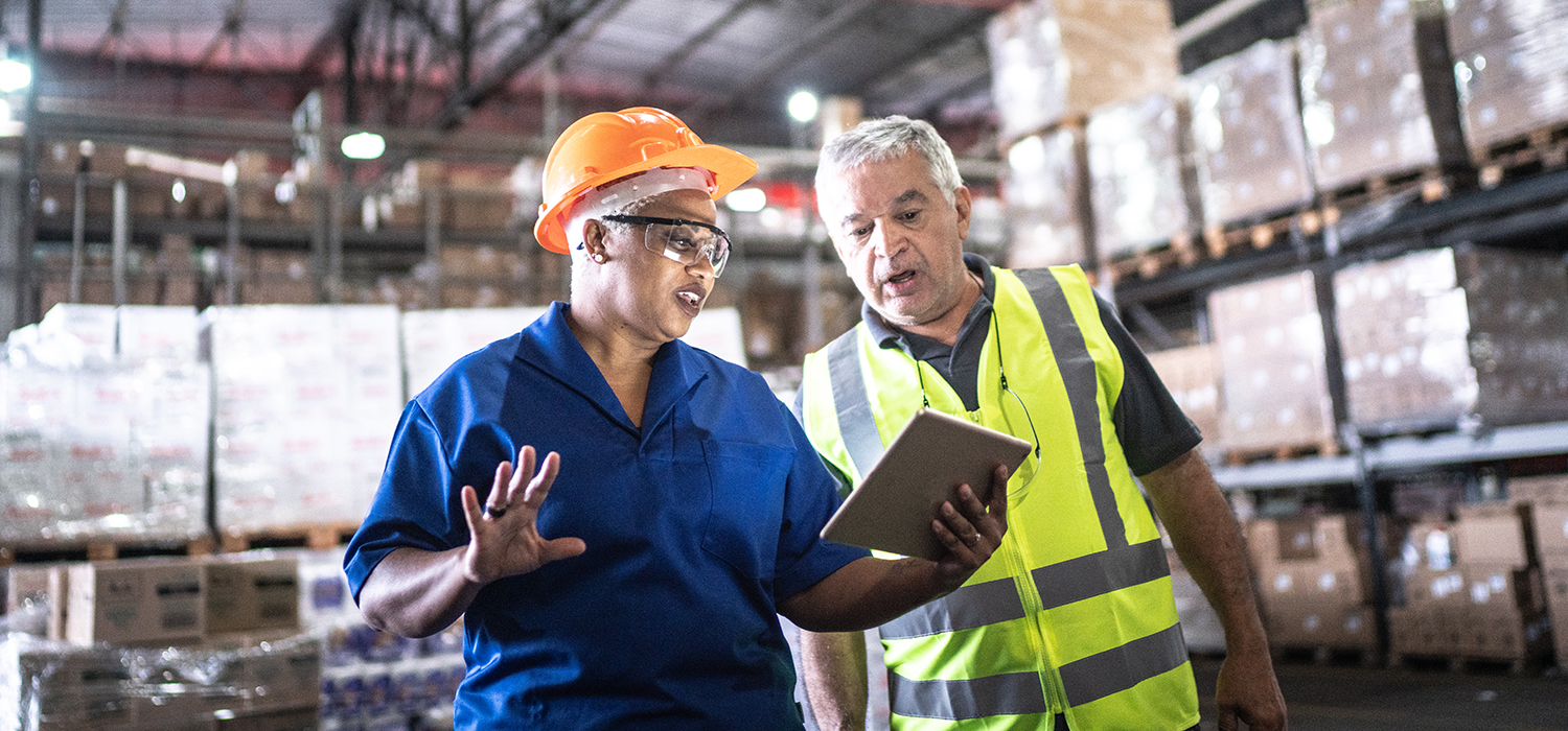 Older workers talk in a warehouse 