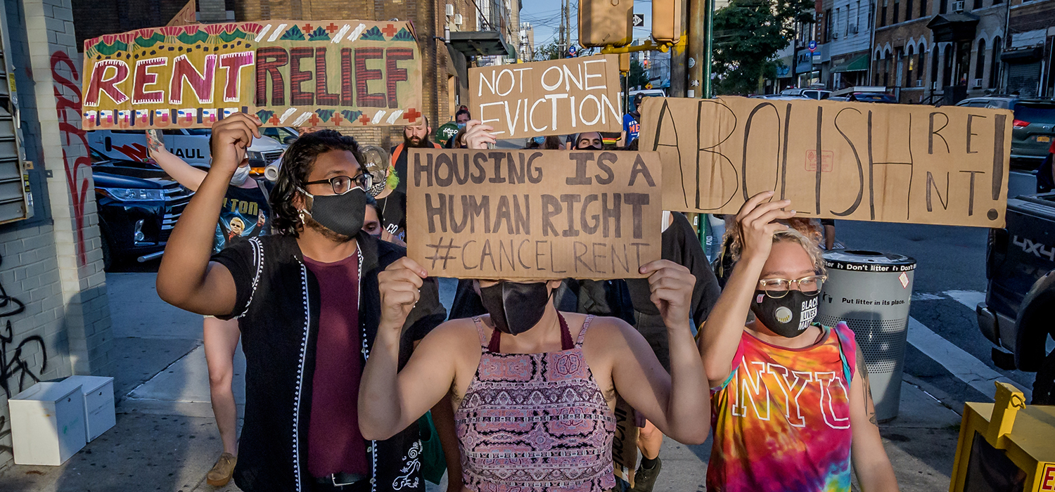 Protesters hold "abolish rent" and "rent relief" signs