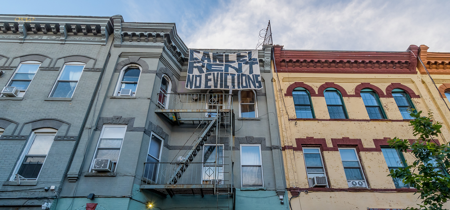 "Cancel rent no evictions" sign hangs from apartment building