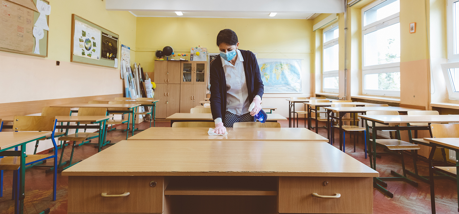Teacher cleans a classroom