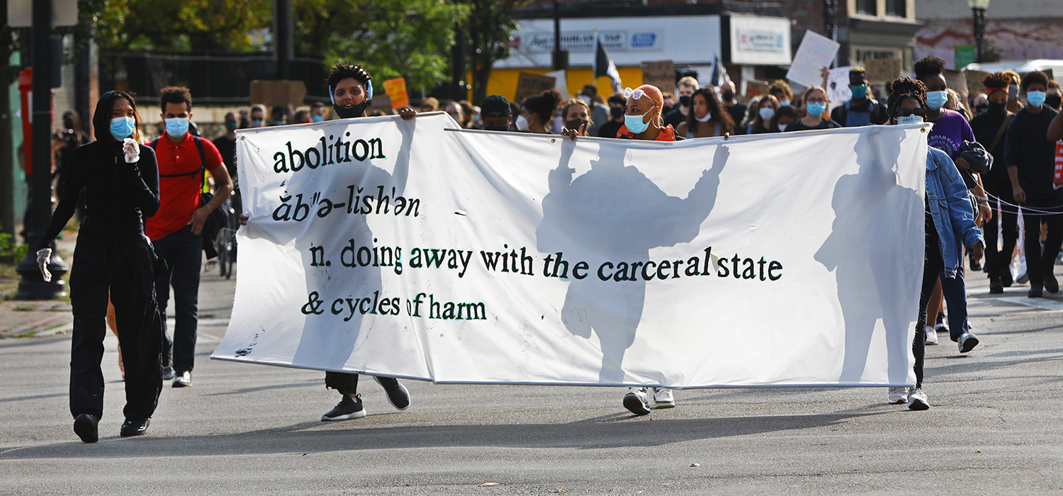 Protesters hold an "abolish" sign