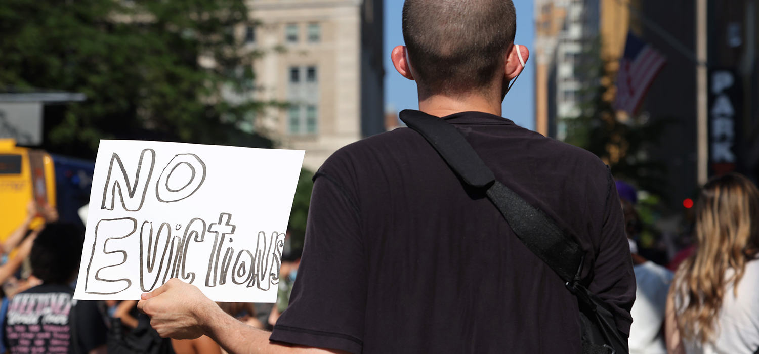 Protester holds a sign that says "no evictions"