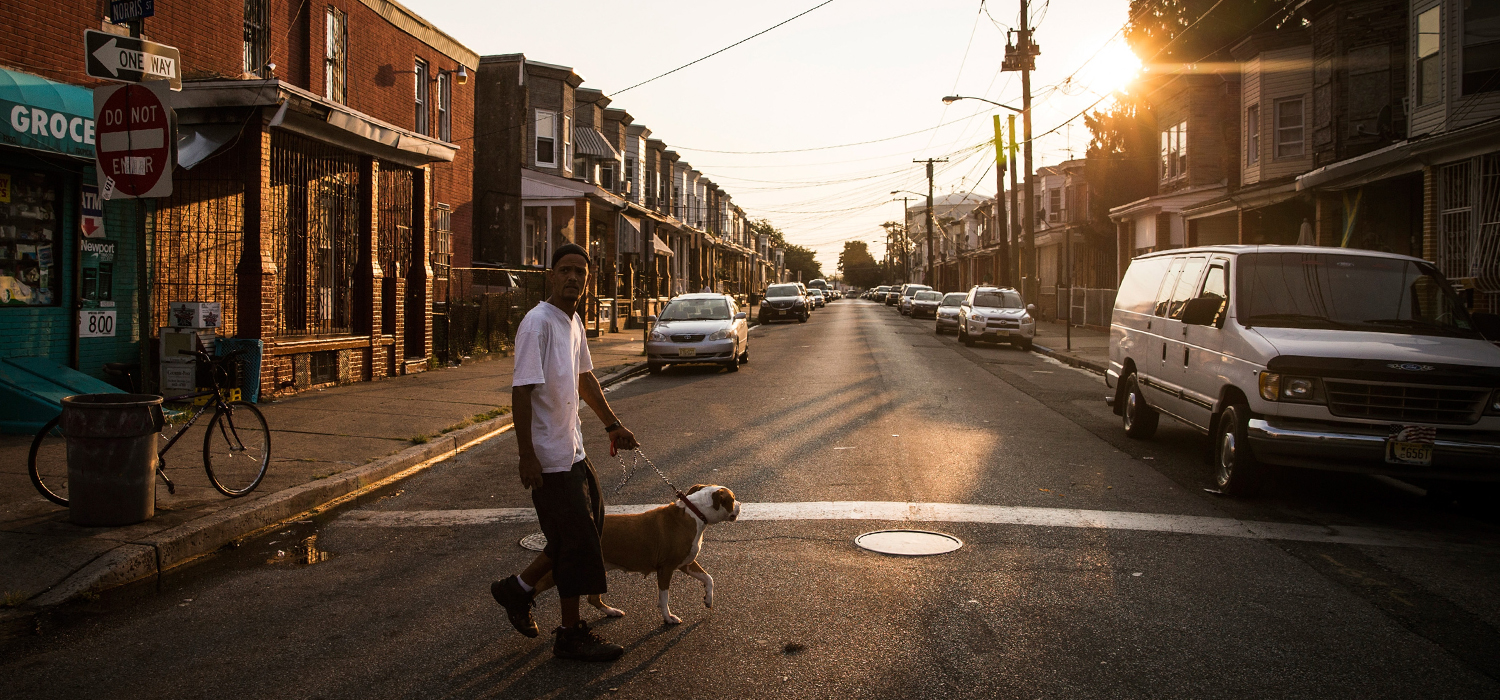 A man walks his dog in the Whitman Park neighborhood of Camden, New Jersey
