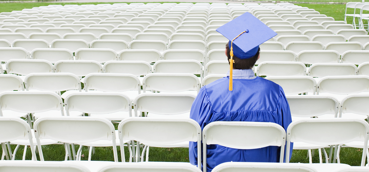 College graduate sits among empty chairs