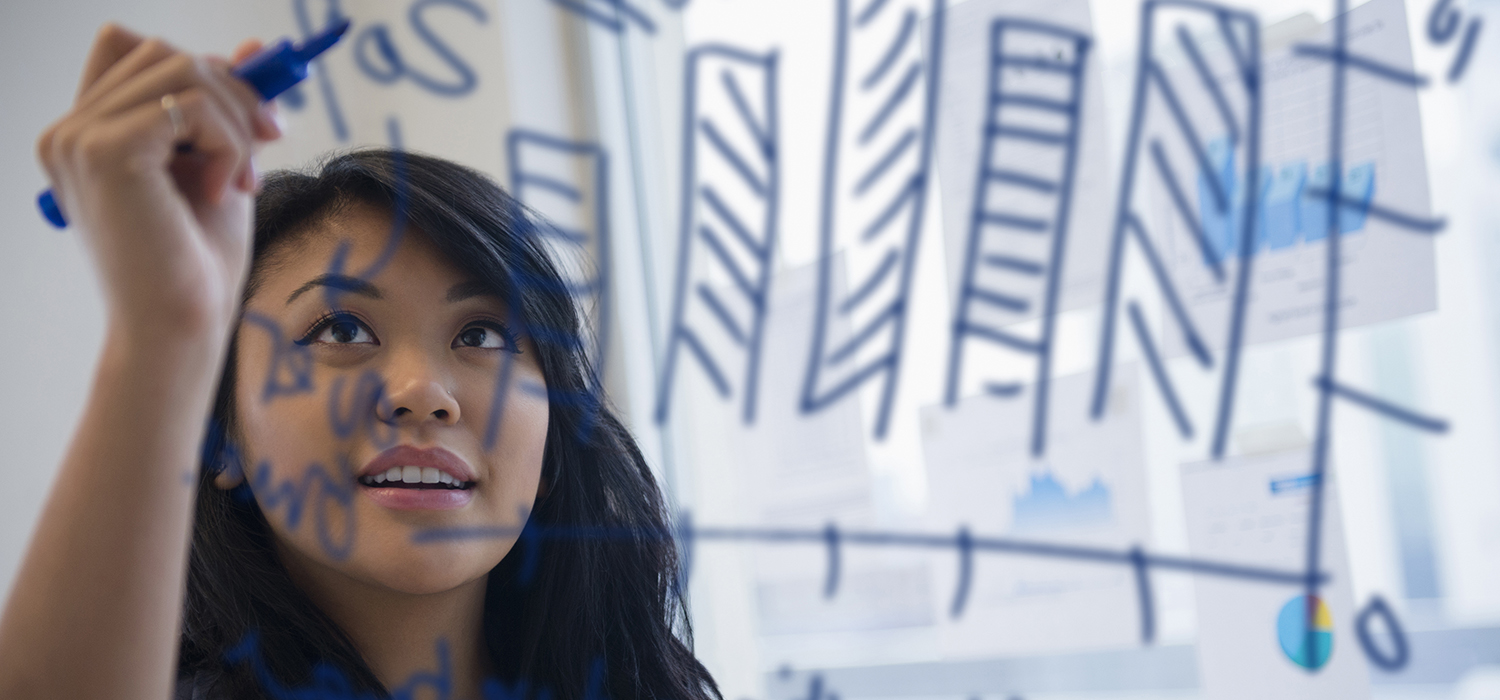 Woman writes with marker on clear board