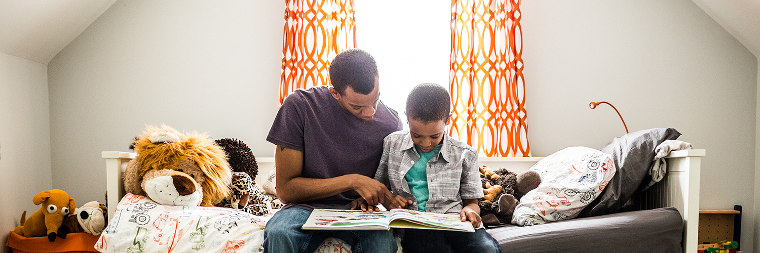 A child and his father read together
