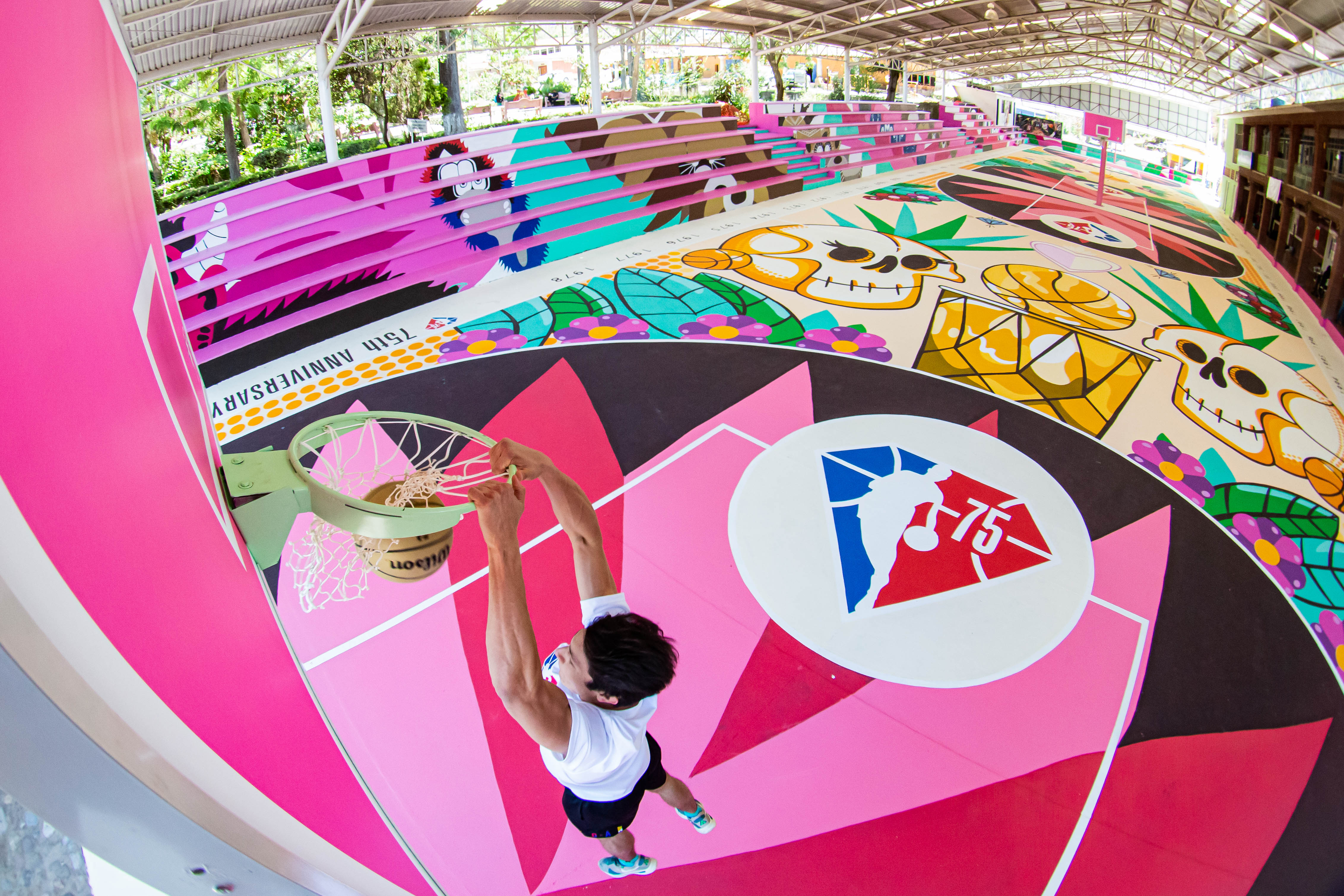 A man playing basketball on a colorful court. 