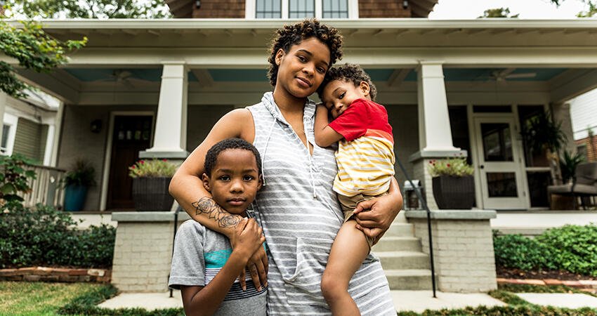 Family stands in front of house