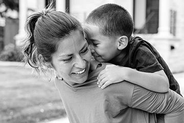 A mother giving a child a piggyback ride