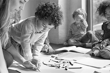 A teacher draws with preschool children.