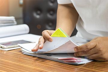 a photo of teacher searching for documents of desk