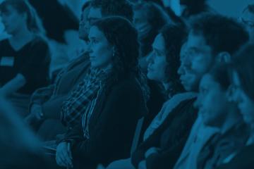 tinted photo of event attendees watching program