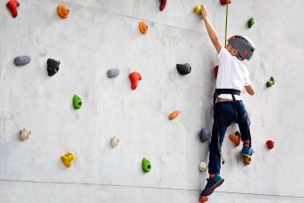 photo of child climbing at a climbing wall