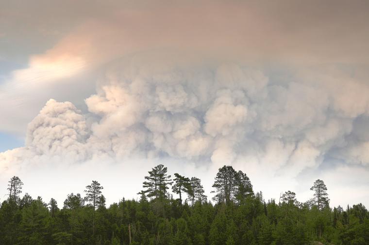 A plumes of smoke from the Camp Fire hangs in the air on Moose Lake as multiple wildfires burning in the Boundary Waters Canoe Area Wilderness prompted its closure and evacuation Tuesday, July 14, 2026 in Ely, Minnesota