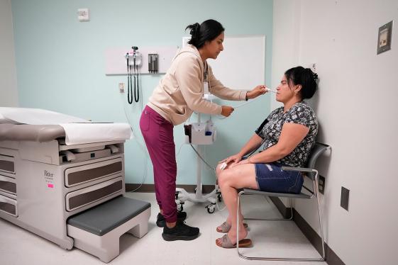 A nurse taking a patient’s blood pressure and temperature at a doctor’s office.