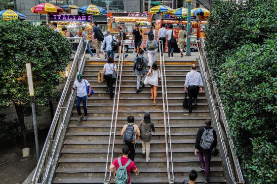 Pedestrians climbing stairs to an outdoor food court in New York City.
