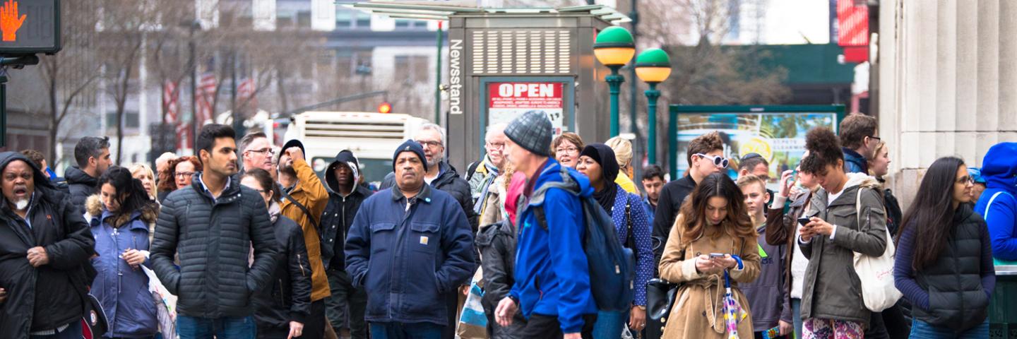 Busy city street scene of diversity of pedestrian people crossing the street.