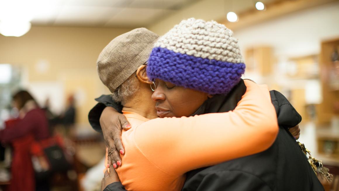 Two women embrace in the Day Center community space at the Downtown Women’s Center in Los Angeles.