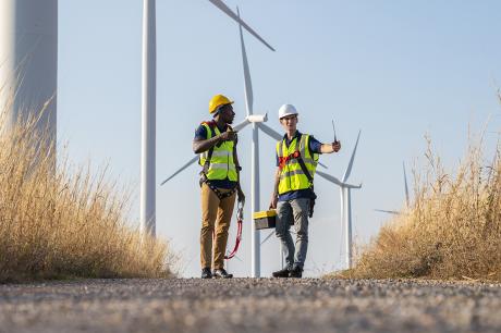 Two workers outside a windmill plant.