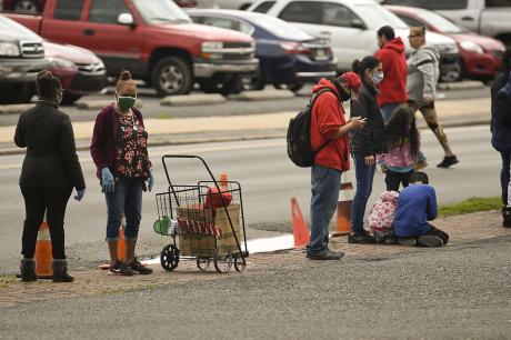  People stand in line along Greenwich Street next to Hope Rescue mission.