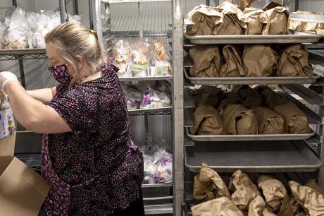Deborah Jendrasko prepares the free bag lunches for students at Deering High School on Friday