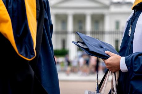 Students from George Washington University wear their graduation gowns outside of the White House