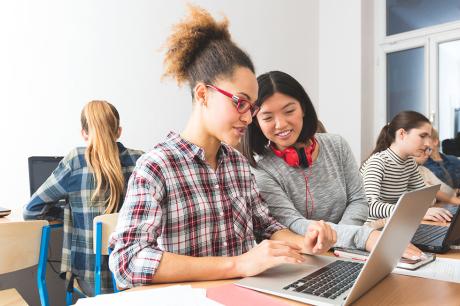 Two students working on a laptop.