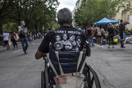A wheelchair-bound man wearing a t-shirt with I can't breathe written on it, takes part in a demonstration near the White House while protesting against police brutality and racism.