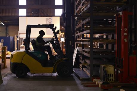 Employee operates lift in a warehouse