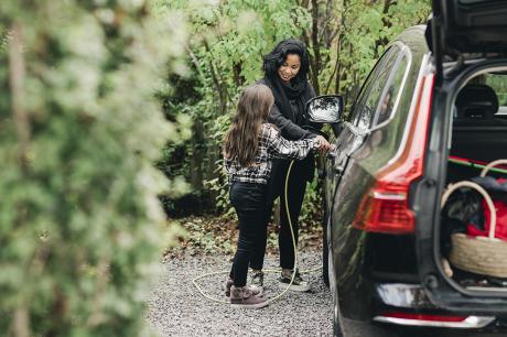 Woman charging an electric car. 