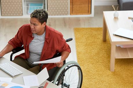 Person works at a desk sitting in a wheelchair