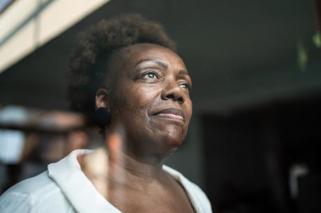 A Black woman looking a window. 