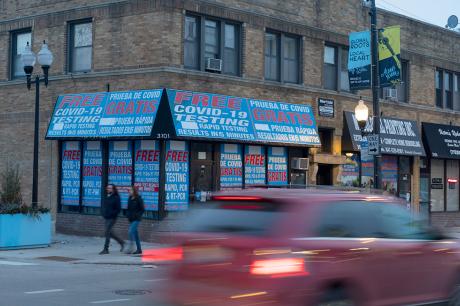 A street corner with a building offering free covid testing. 