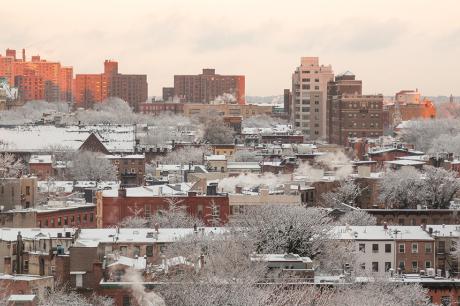 A wide shot of a city with snow on the ground.